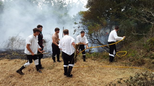 El grupo de gaiteiros apagando el fuego en Santa Comba 