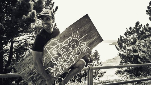 El actor Adrián Castiñeiras sujeta un cartel con el nombre de su nuevo local