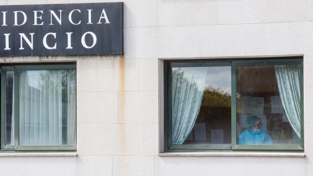 Una sanitaria en una ventana de la residencia de ancianos de O Incio, en Lugo.