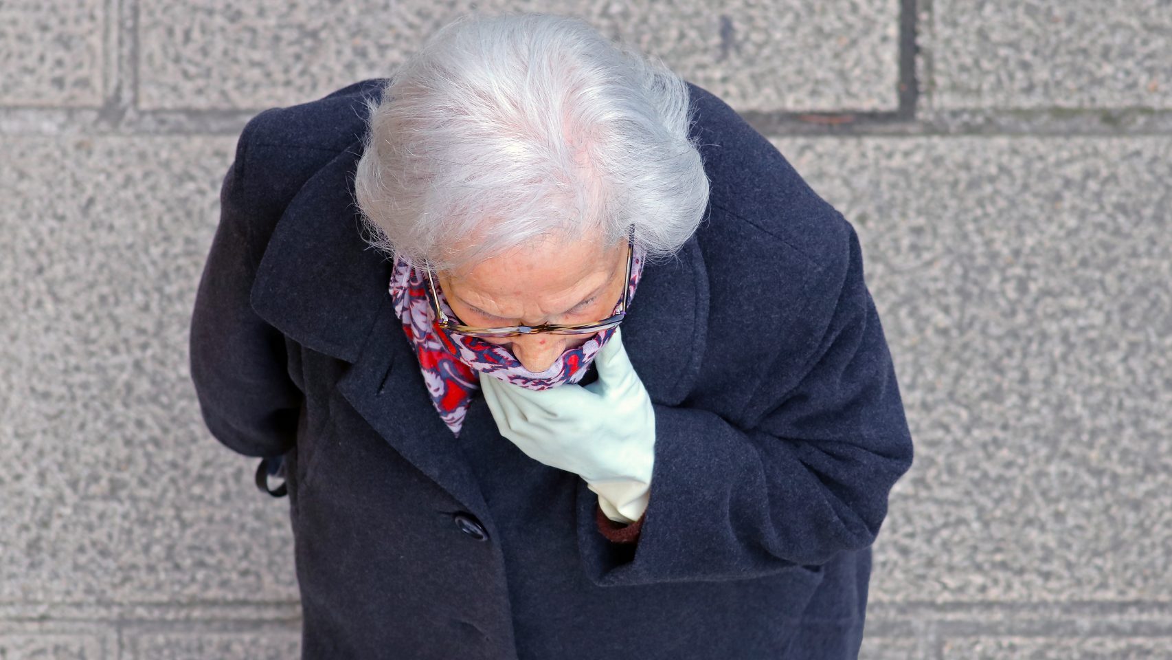Una mujer mayor de Lugo se cubre la cara.