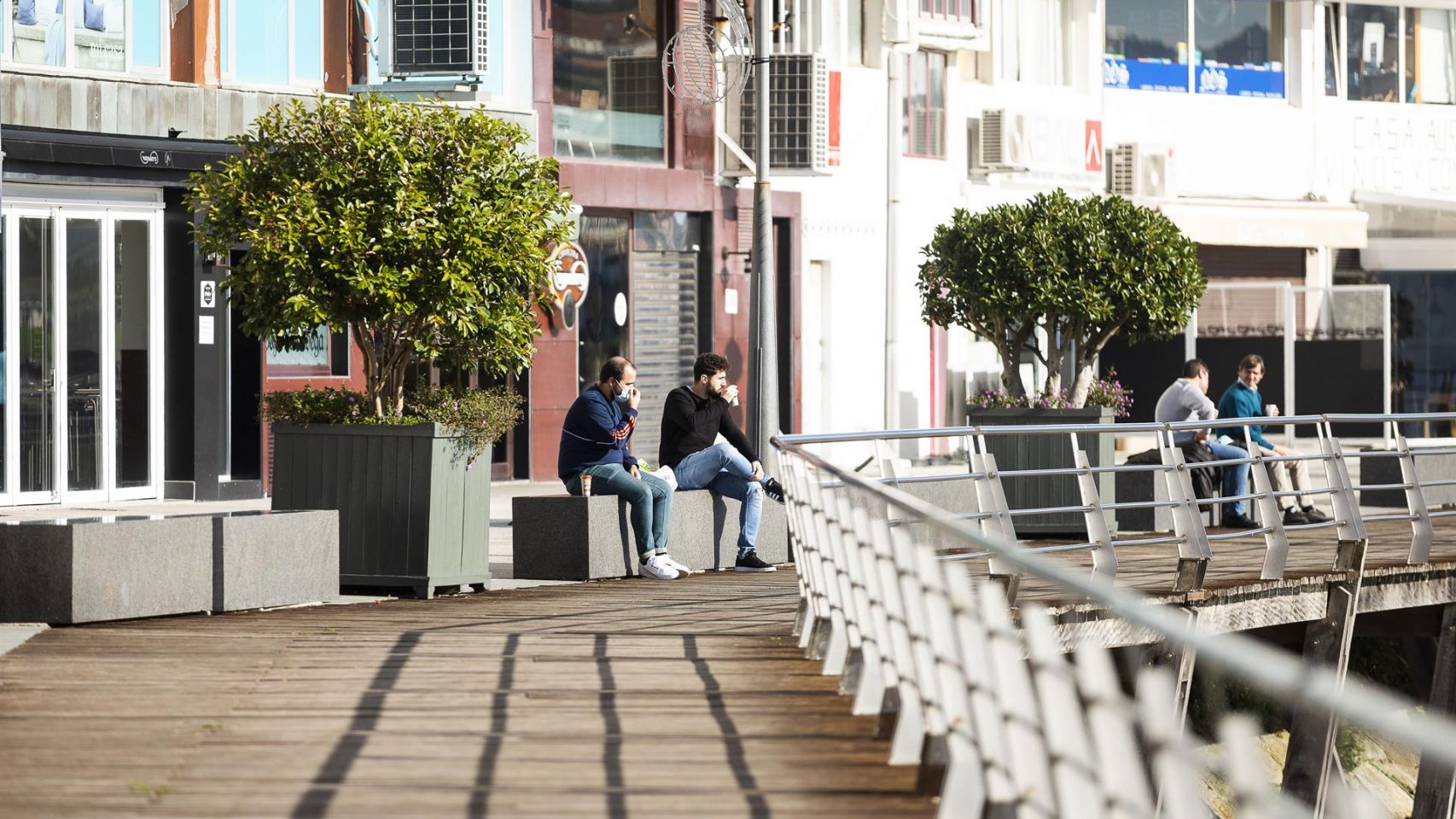 Dos personas permanecen sentadas en un banco de Sanxenxo
