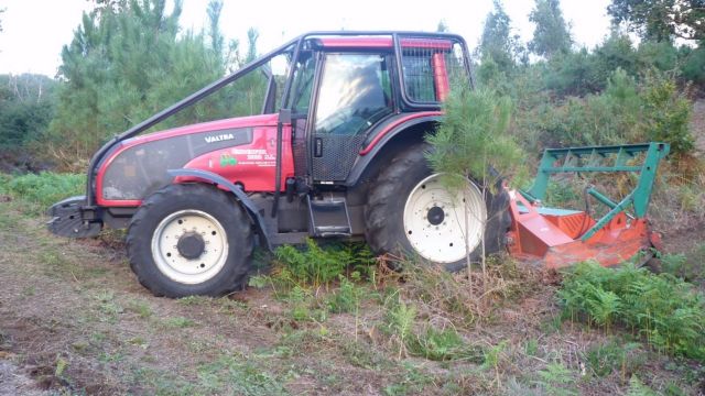 Un tractor desbroza en una finca en Galicia.