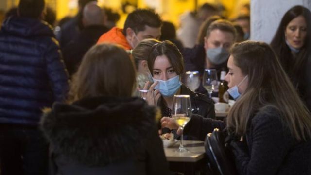 Un grupo de personas toma consumiciones en una terraza.