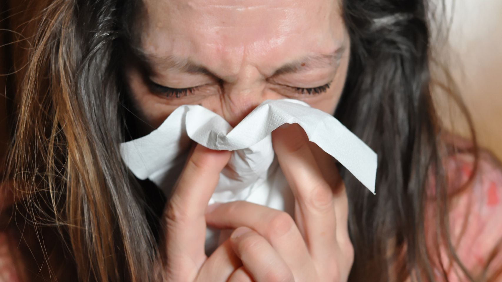 Una mujer con gripe en una foto de archivo.