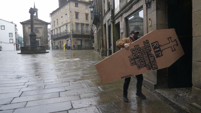 Antón Lago, propietario del Bar La Gramola (Santiago de Compostela), coloca un ataúd en la barra de su local.
