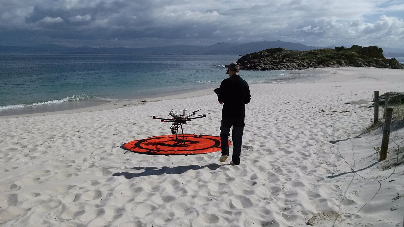 Investigador del proyecto Bewast con un dron en una playa viguesa.
