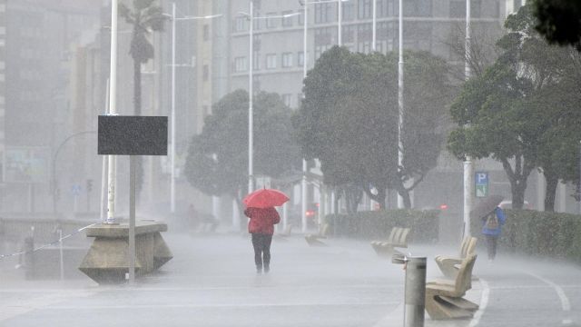 Una mujer bajo la lluvia en el Paseo Marítimo de A Coruña.