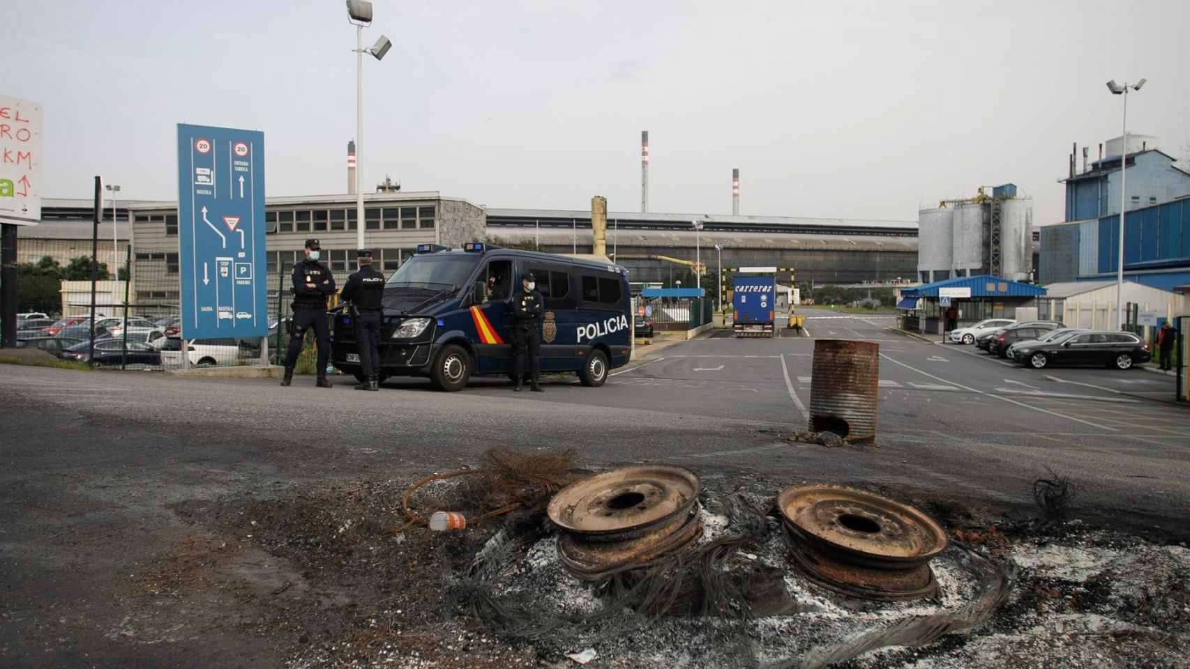 Varios agentes vigilan con un furgón policial en las inmediaciones de la fábrica de Alu Ibérica en A Coruña.