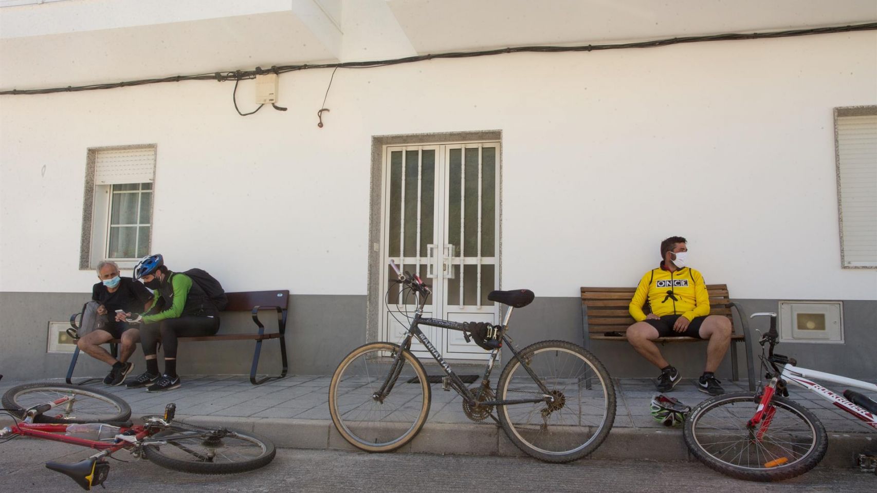 Tres peregrinos descansan junto a sus bicicletas en Triacastela (Lugo).
