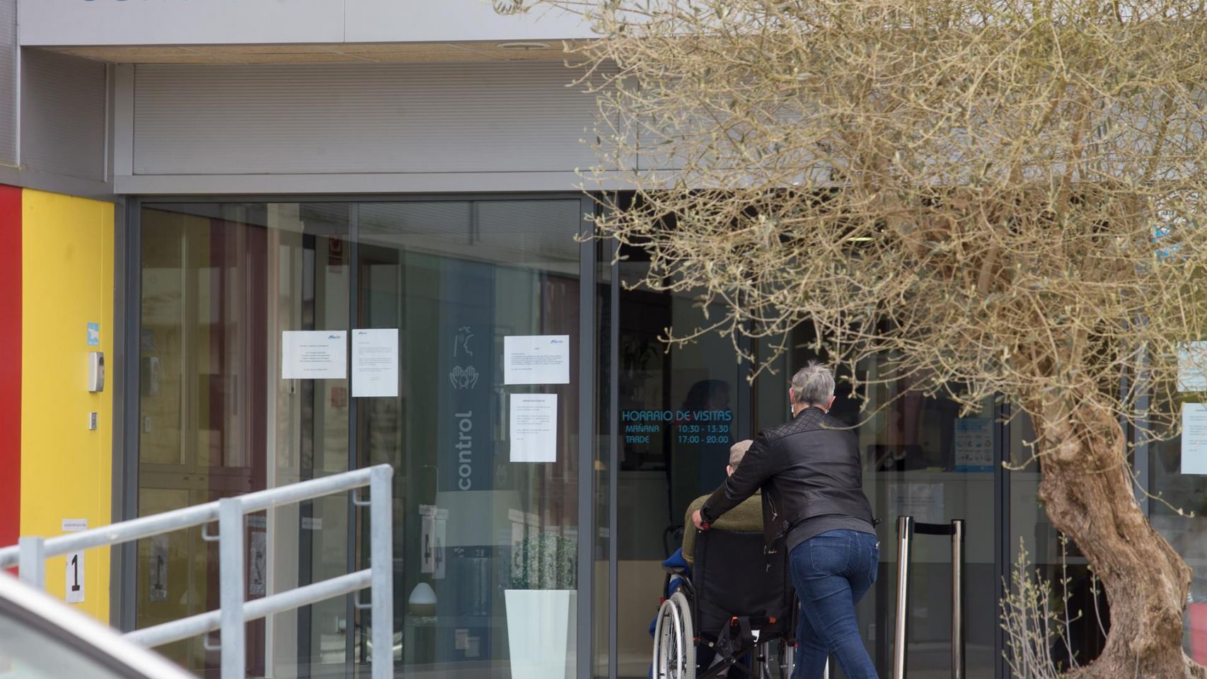 Una mujer pasea junto a un anciano en silla de ruedas hacia la residencia Albertia, en Lugo.