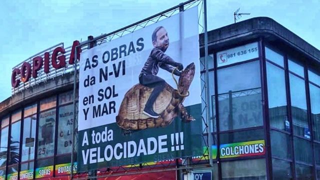 Cartel en Oleiros de la campaña contra la lentitud en las obras