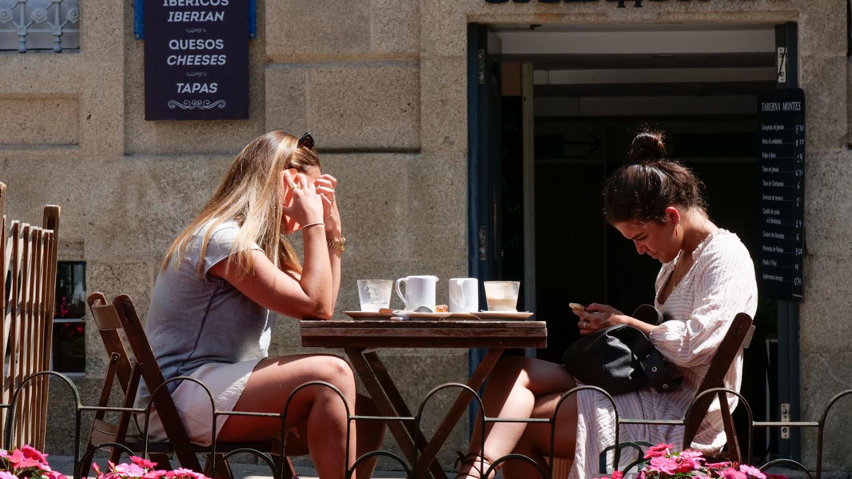 Dos mujeres en la terraza de un restaurante de la Rua da Raiña, en Santiago.
