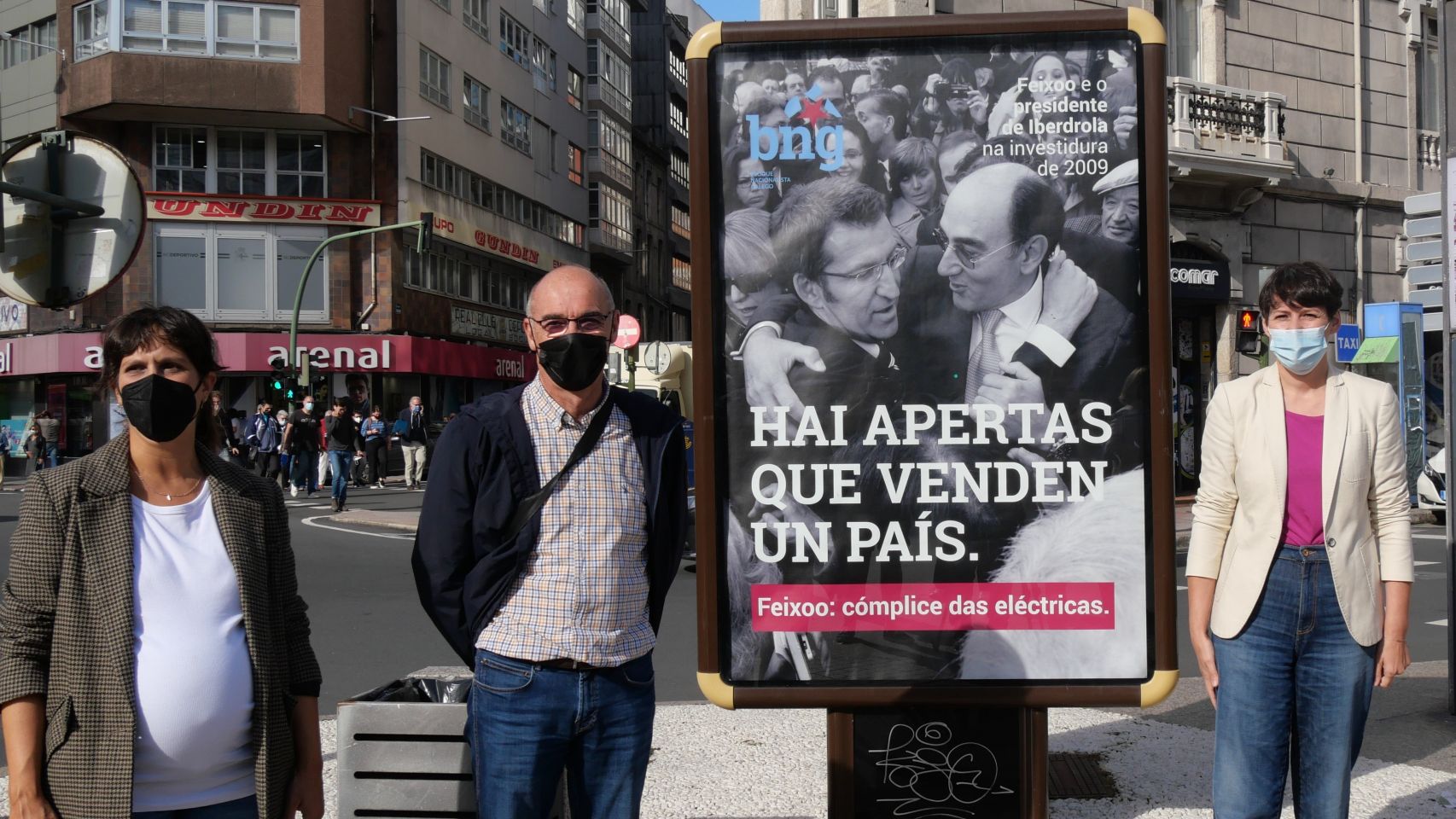 Representantes del BNG con el cartel publicitario colocado en A Coruña.