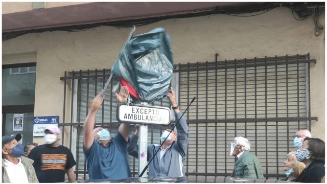 Vecinos retirando el cobertor de la señal de reservado para ambulancias.