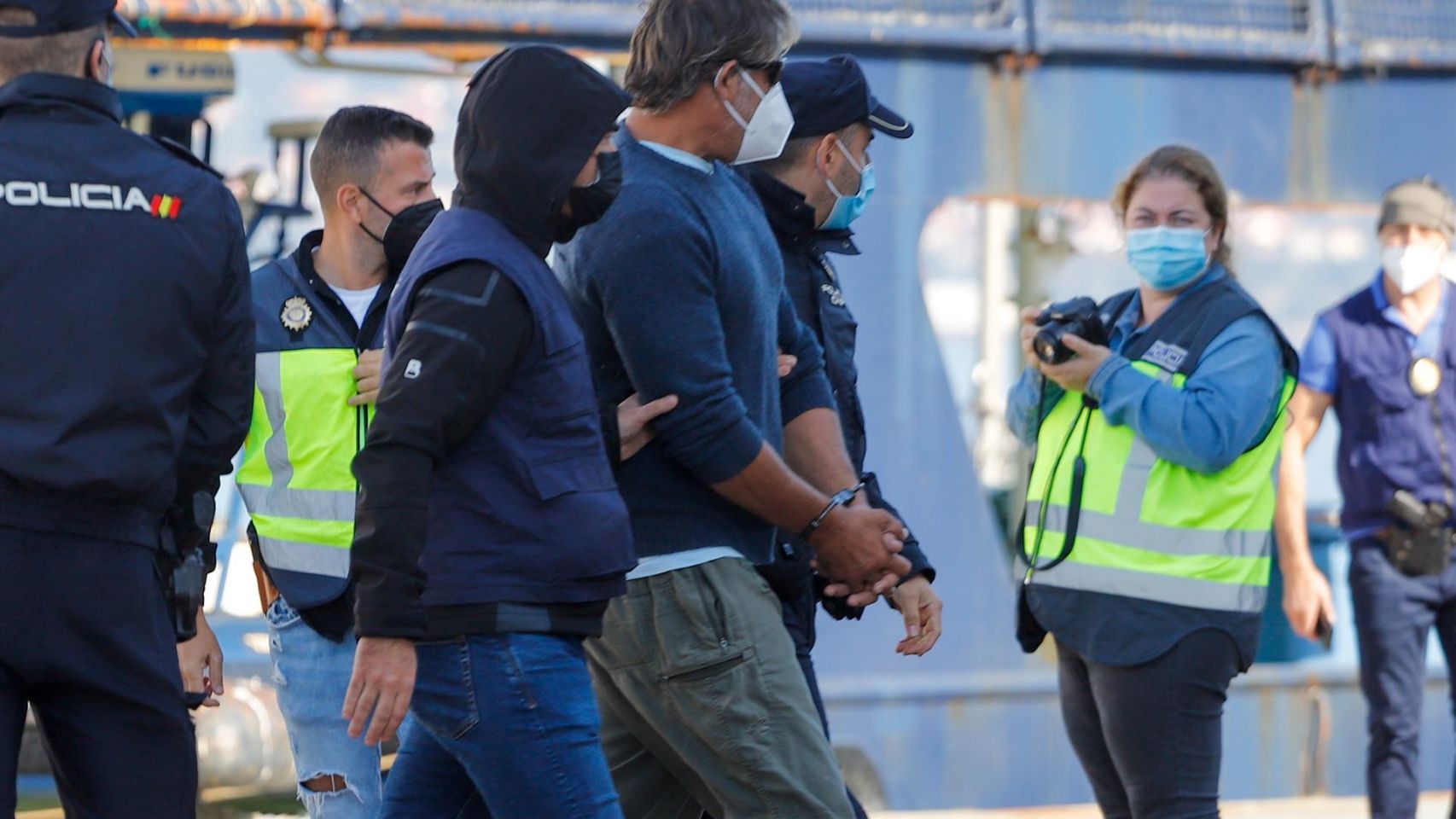 Varios policías acompañan a uno de los detenidos del velero interceptado en aguas del Atlántico norte