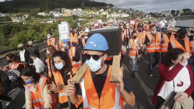 Dos hombres portan sobre sus hombros una simulación de un féretro, en una manifestación por el futuro industrial de A Mariña el 17 de octubre.