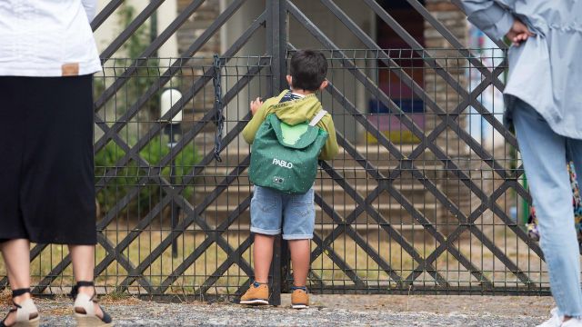 Un niño se asoma a las puertas del CEIP Manuel Mallo de Nadela, durante el primer día del curso escolar 2021-2022.