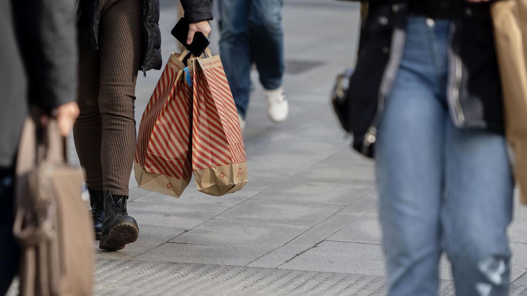 Una mujer camina con bolsas con compras, a 25 de noviembre de 2021, en Madrid (España).