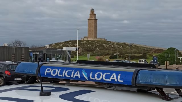 Un coche de la Policía Local de A Coruña frente a la Torre de Hércules.