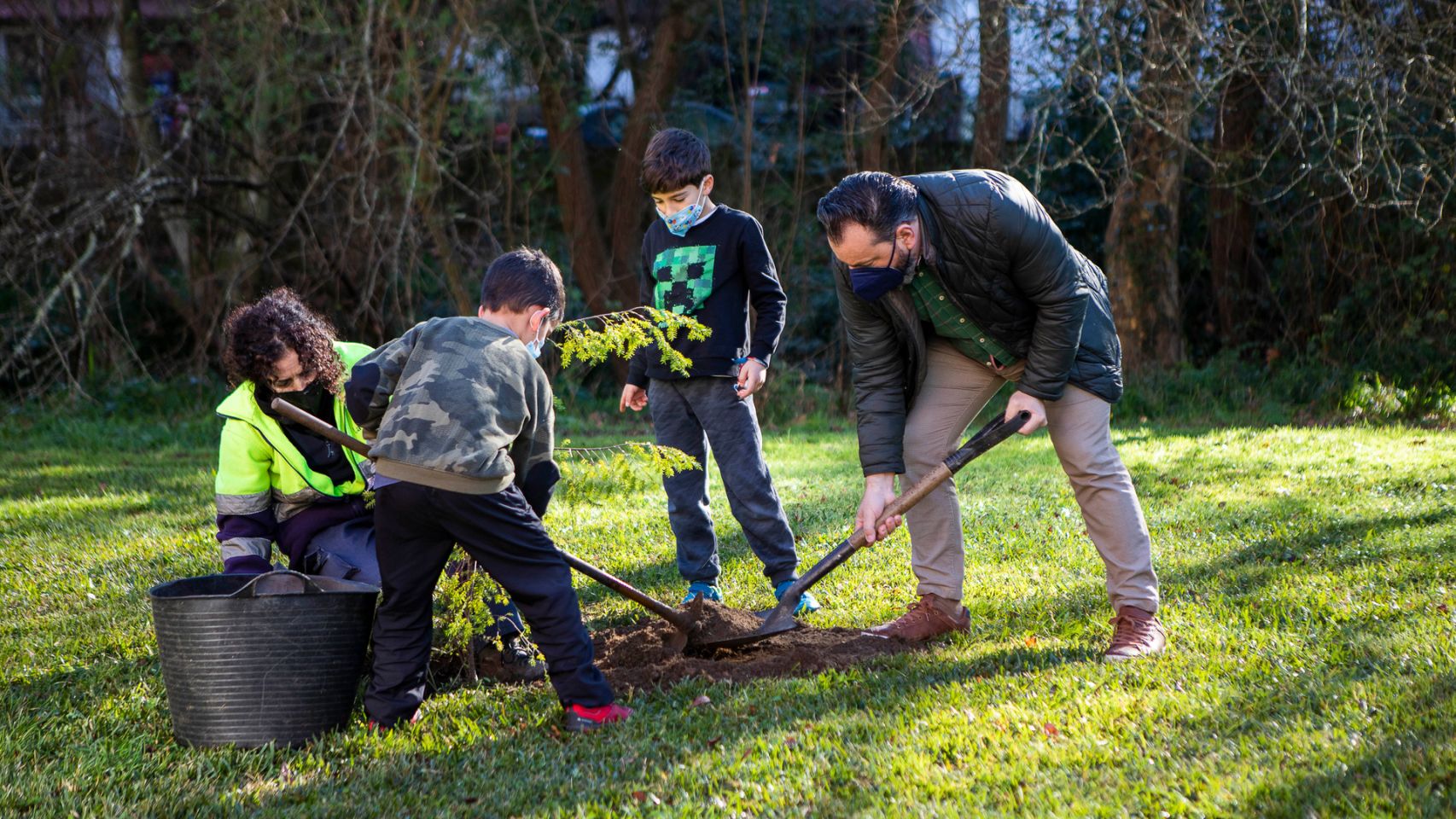 Niños plantando un árbol junto al alcalde de Gondomar.