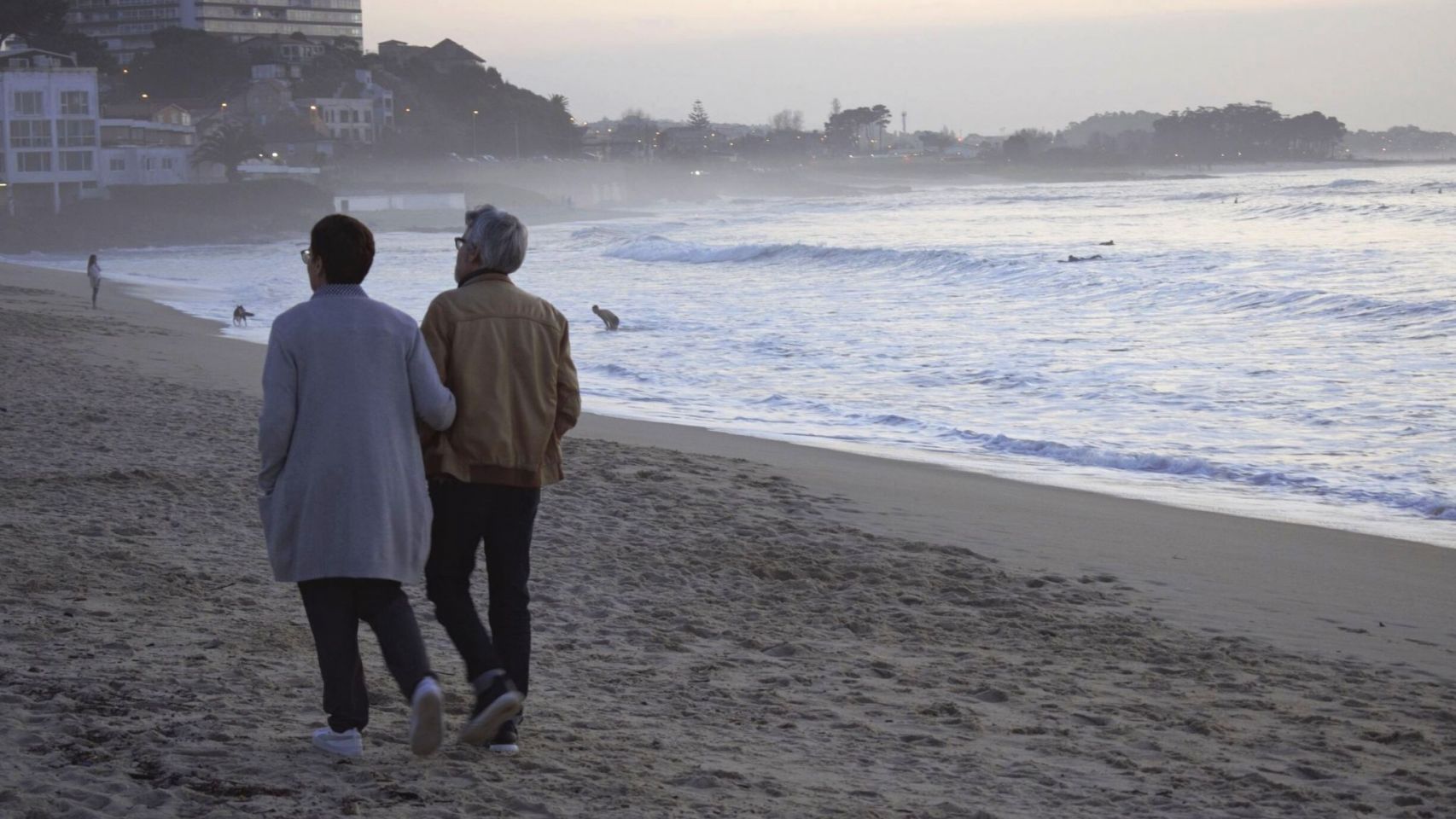 Una pareja pasea por la playa de Samil en Vigo.