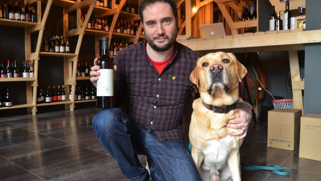 Xabier Arbués con una botella de Riquiño y su perro, Floc.