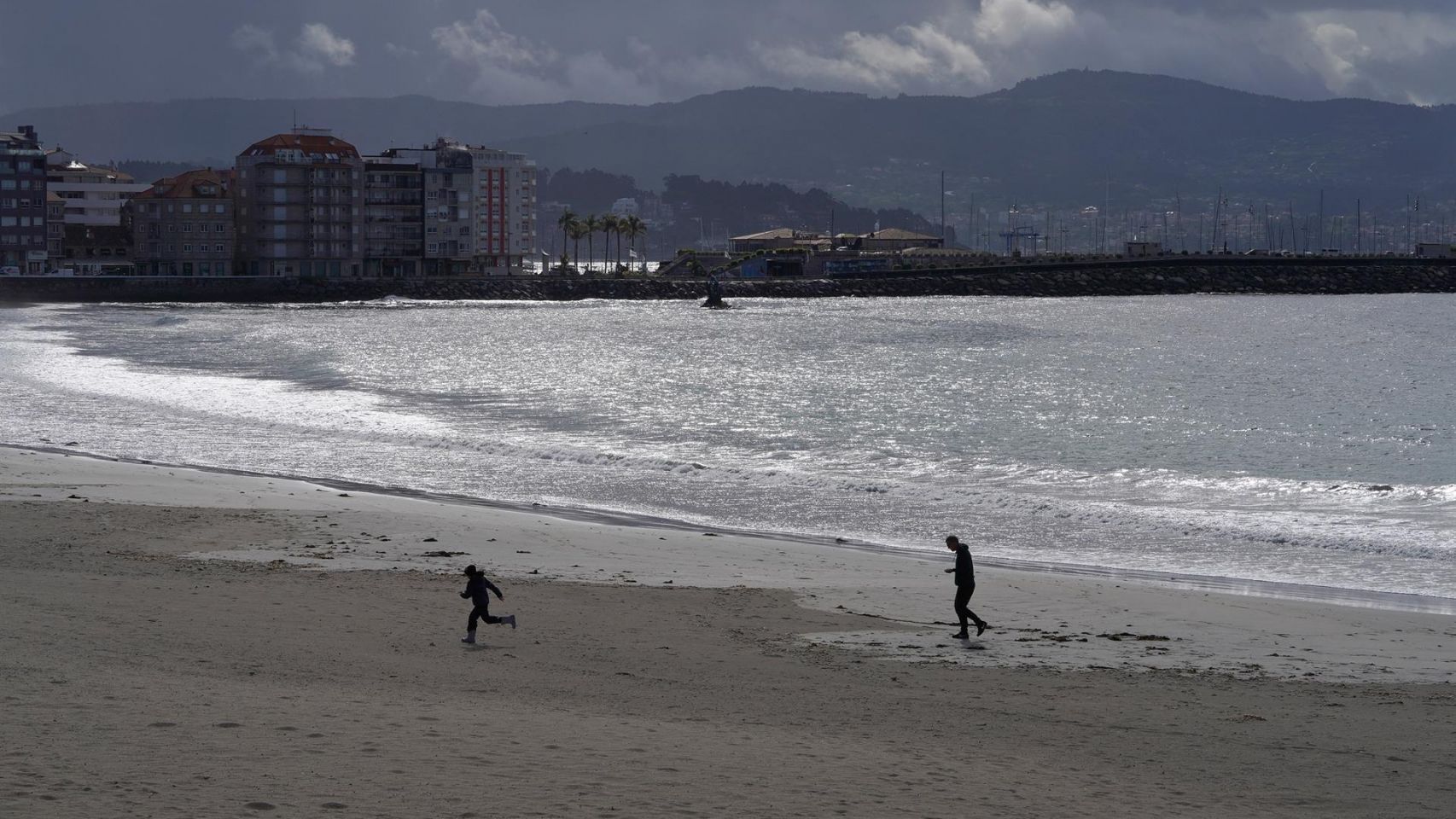 Varias personas pasean por la playa en la que falleció Juan Tábara.