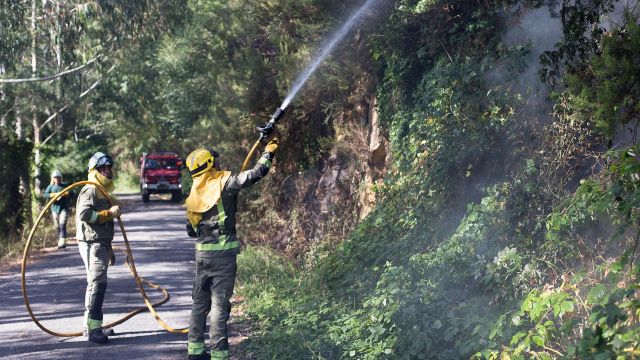 Dos bomberos en un incendio forestal en la parroquia de Cubilledo.