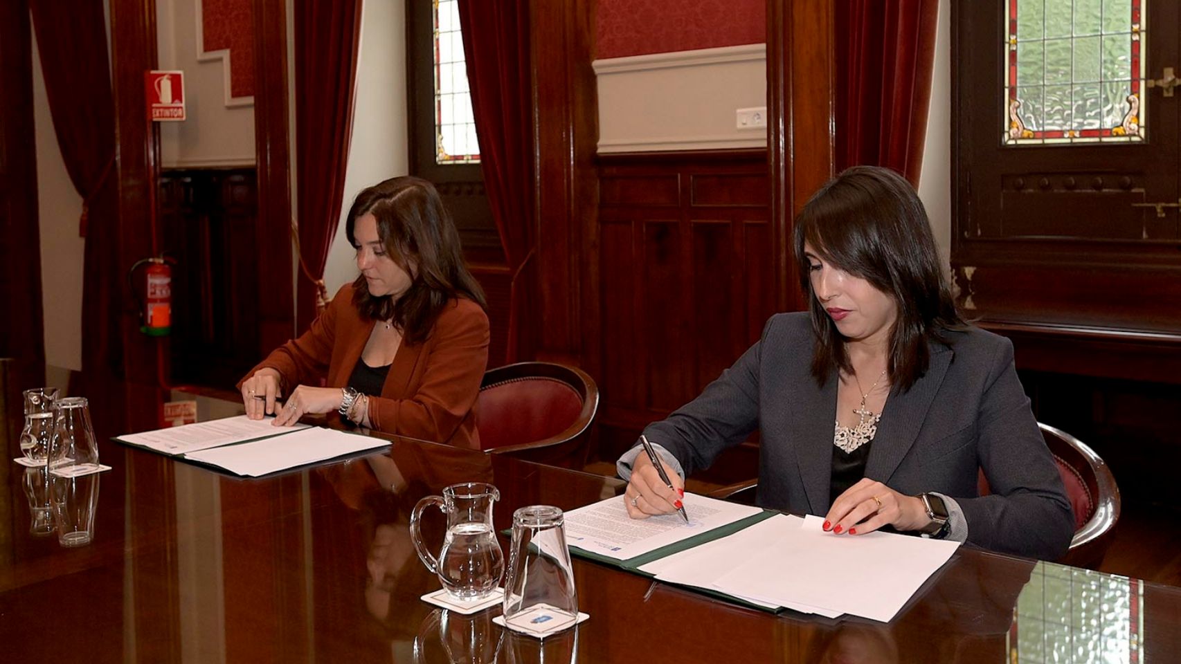 Inés Rey y María Jesus Lorenzana firman el convenio de colaboración.