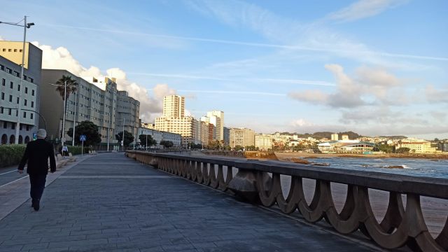 Un hombre camina por el Paseo Marítimo de A Coruña.