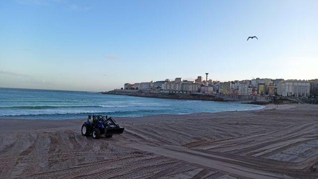 Un tractor trabaja en la playa del Orzán de A Coruña.