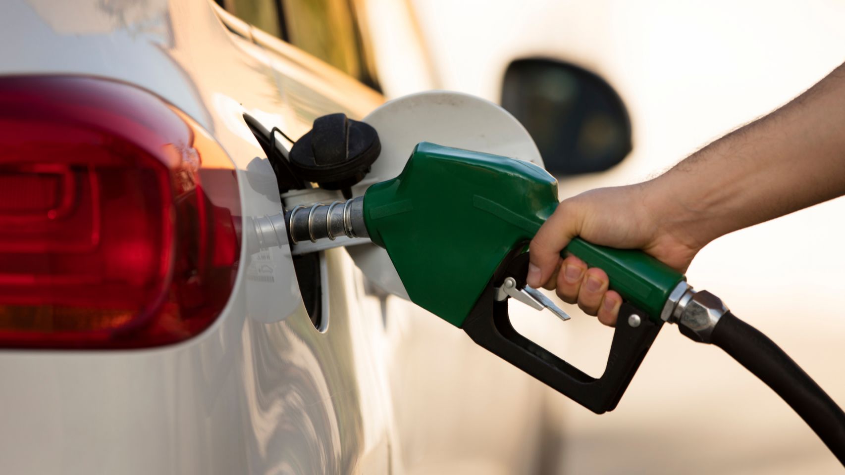 Una persona llenando el depósito de gasolina de un vehículo. 