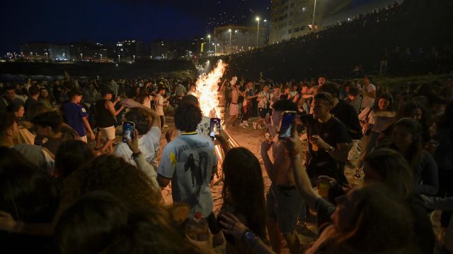 Centenares de personas frente a una hoguera en la Noche de San Juan, a 23 de junio de 2022, en A Coruña. 
