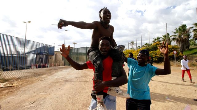 Varios migrantes se dirigen al Centro Temporal de Inmigrantes (CETI), mientras celebran el salto de la valla de Melilla el 24 de junio.