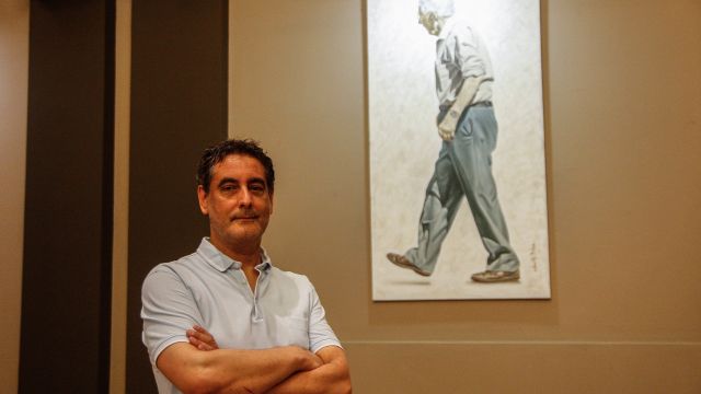 El pintor Roberto Díaz posa con su cuadro.