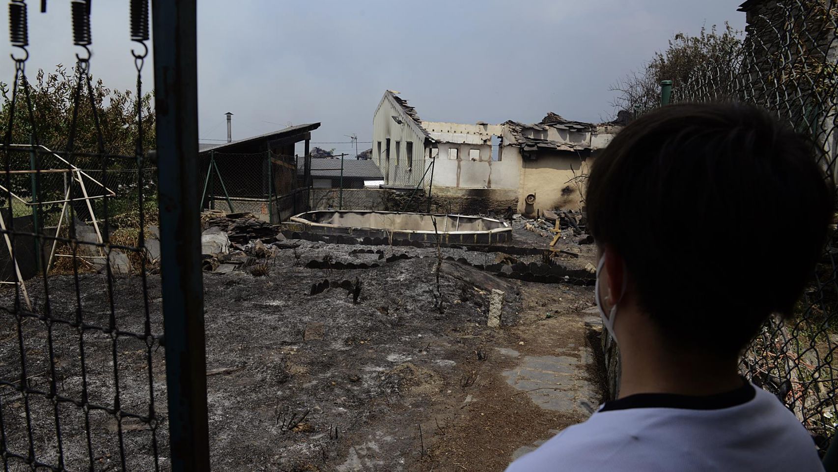Un vecino observa una zona de viviendas afectadas por el fuego en O Barco de Valdeorras.