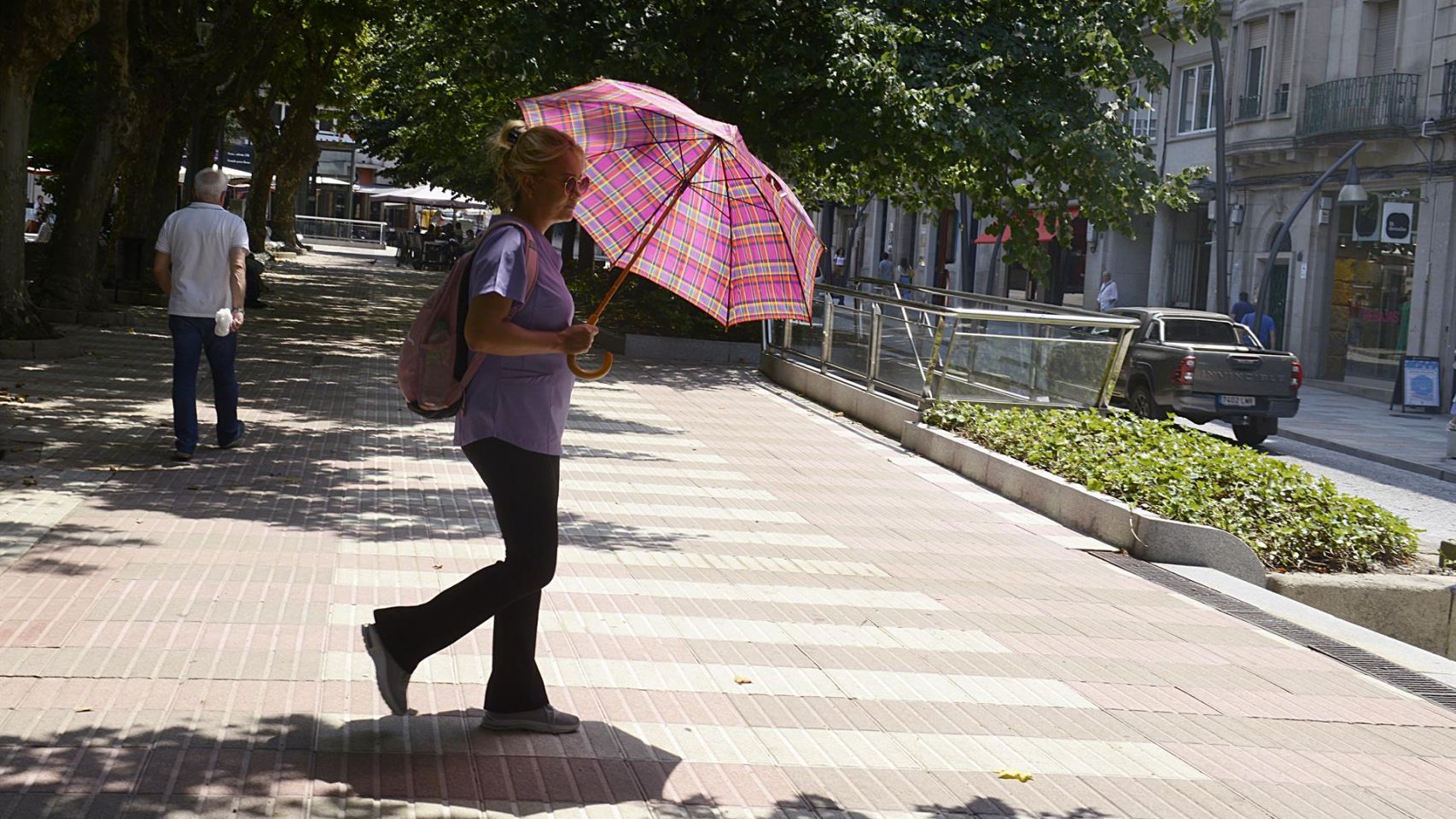 Una mujer camina por una vía en plena ola de calor en Ourense.