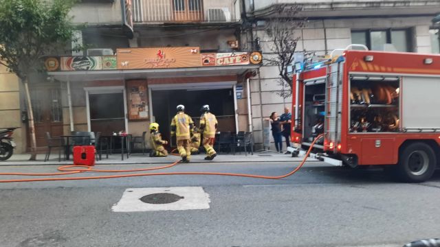 Bomberos de Vigo sofocan las llamas en la cafetería Caballo Rojo. 