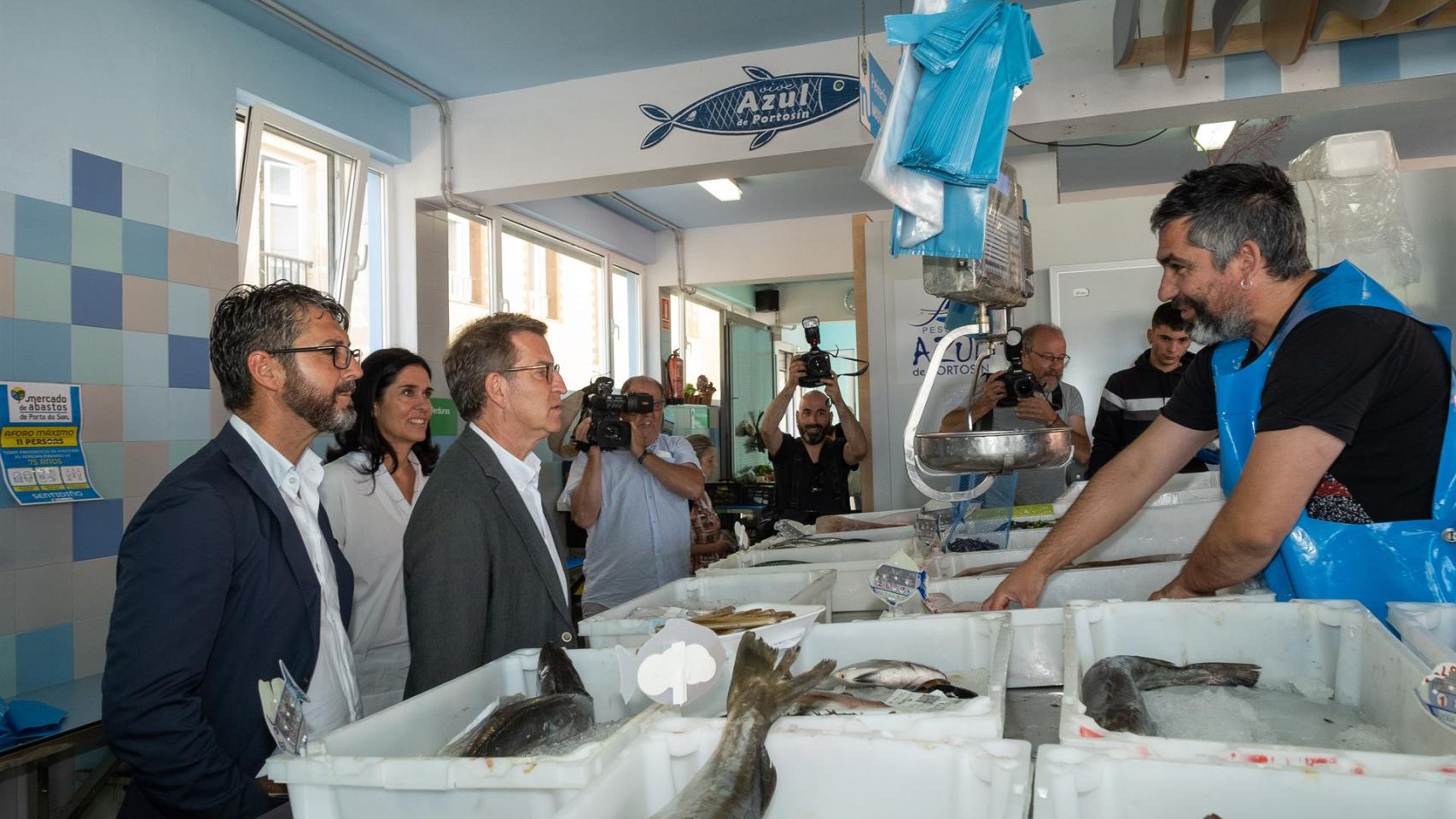 El presidente del Partido Popular, Alberto Núñez Feijóo, charla con un pescadero durante su visita a Porto do Son
