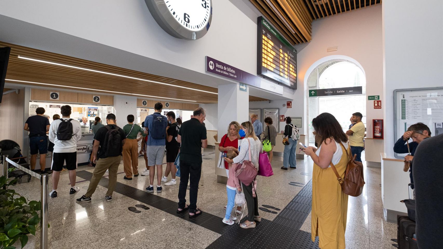 Usuarios hacen cola en la estación de tren de Santiago para conseguir los abonos gratuitos de Renfe.