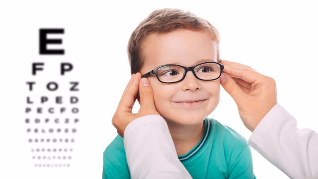 Oculista pone las gafas nuevas a un niño.