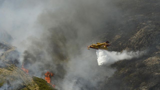 Un hidroavión realiza labores de extinción de un incendio forestal en la Serra do Leboreiro, en el parque natural de Baixa Limia e Serra do Xurés (Ourense). 