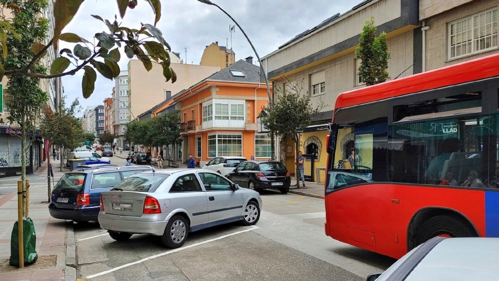 Un autobús pasa por la avenida de Os Mallos de A Coruña tras colocar las plazas de aparcamiento en batería.