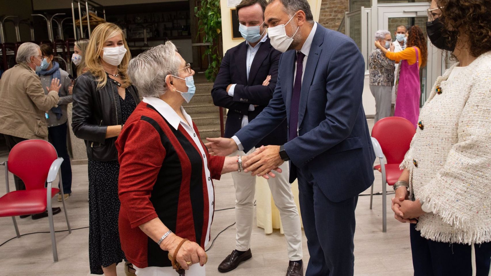 El conselleiro de Sanidade, Julio García Comesaña, saluda a Nieves Cabo, la primera gallega en ser inmunizada.