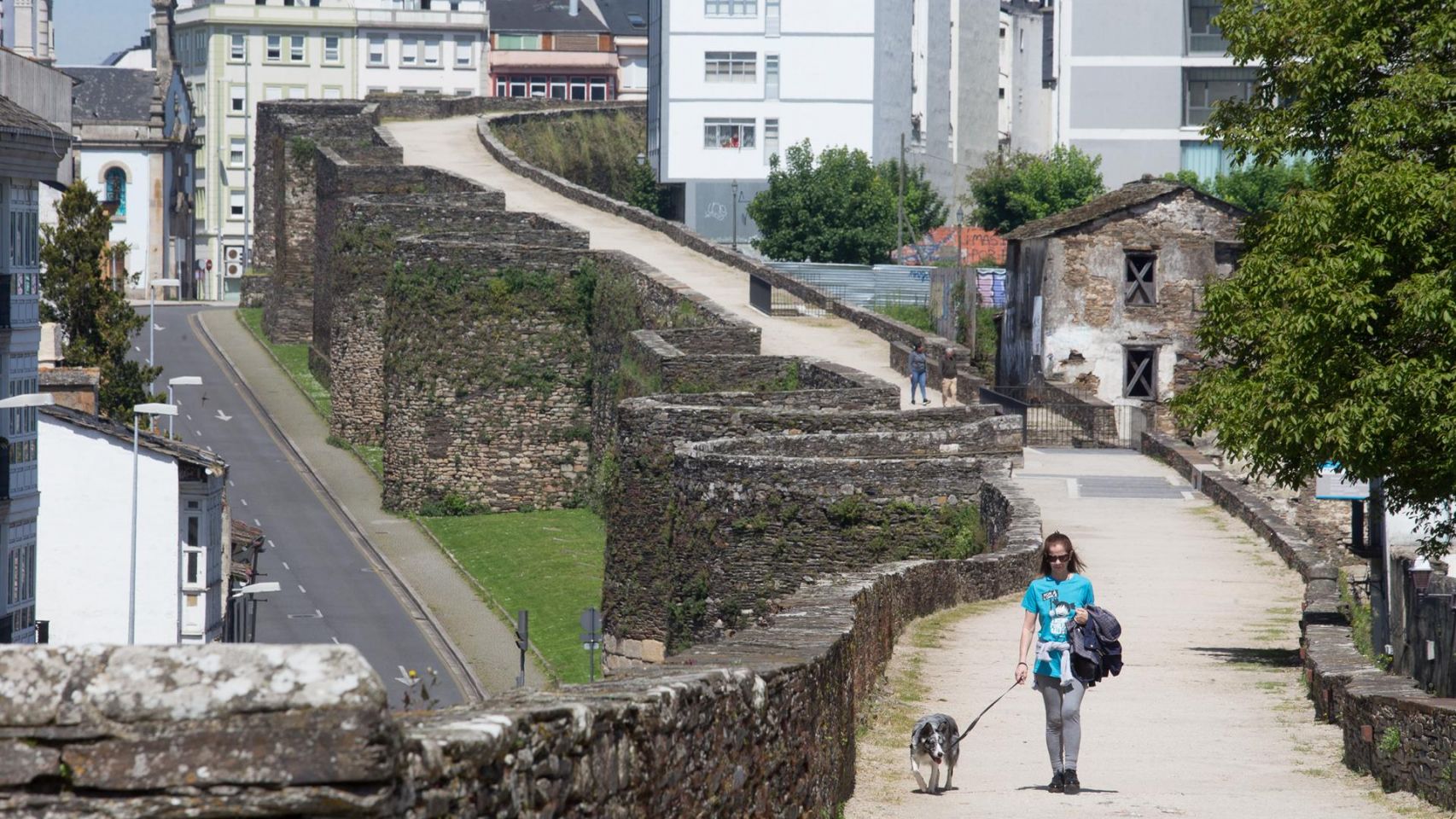 Una mujer pasea a su perro durante el Día de la Madre en Lugo.