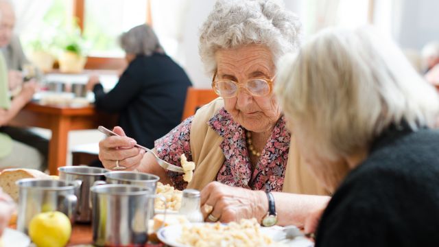 Persona mayor comiendo.
