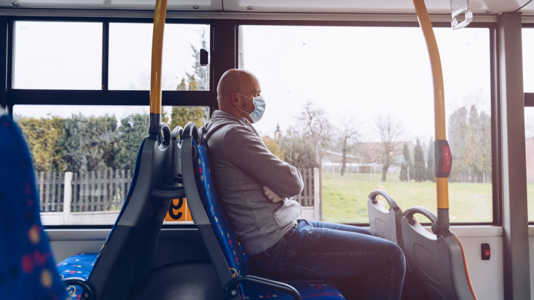 Un hombre con mascarilla en un autobús.