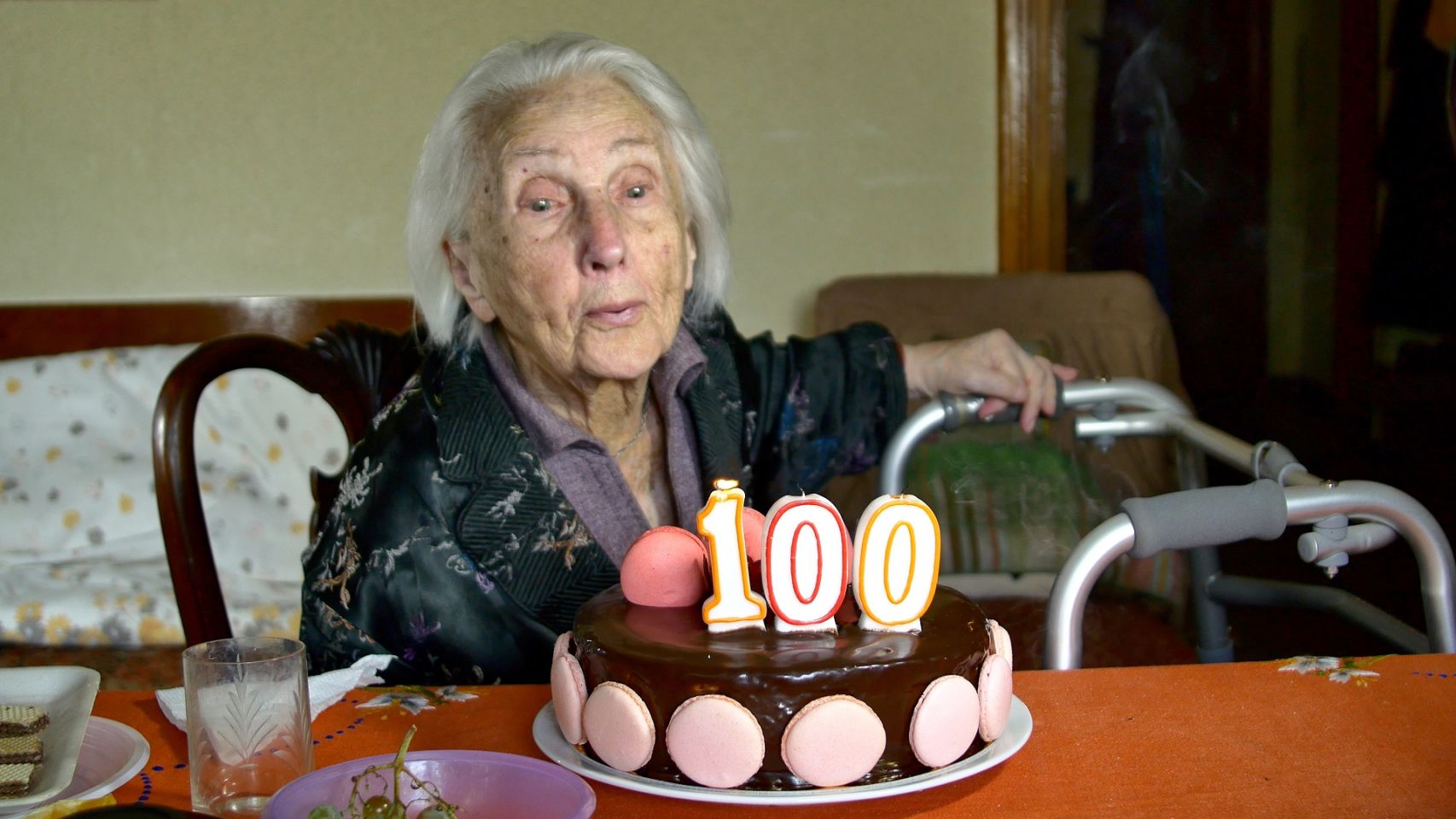 Una mujer sopla las velas por su 100 cumpleaños.
