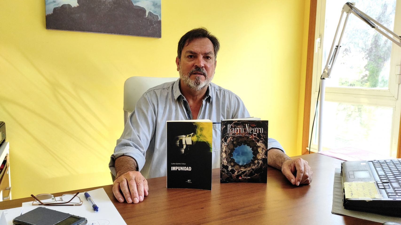 Carlos Quintía en su despacho con dos de sus libros publicados. 