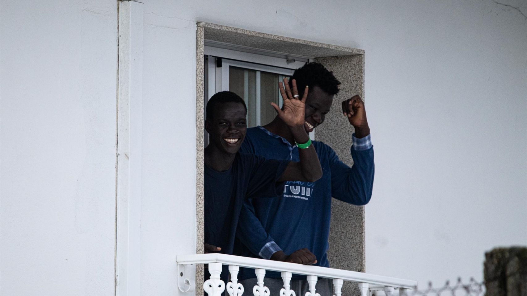 Dos jóvenes migrantes en la terraza del hotel Baixamar de Sanxenxo.
